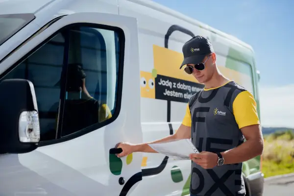 Kurier InPost otwiera drzwi vana, trzymając dokumenty. Czy InPost pracuje w soboty? Tak, dostawy są realizowane!